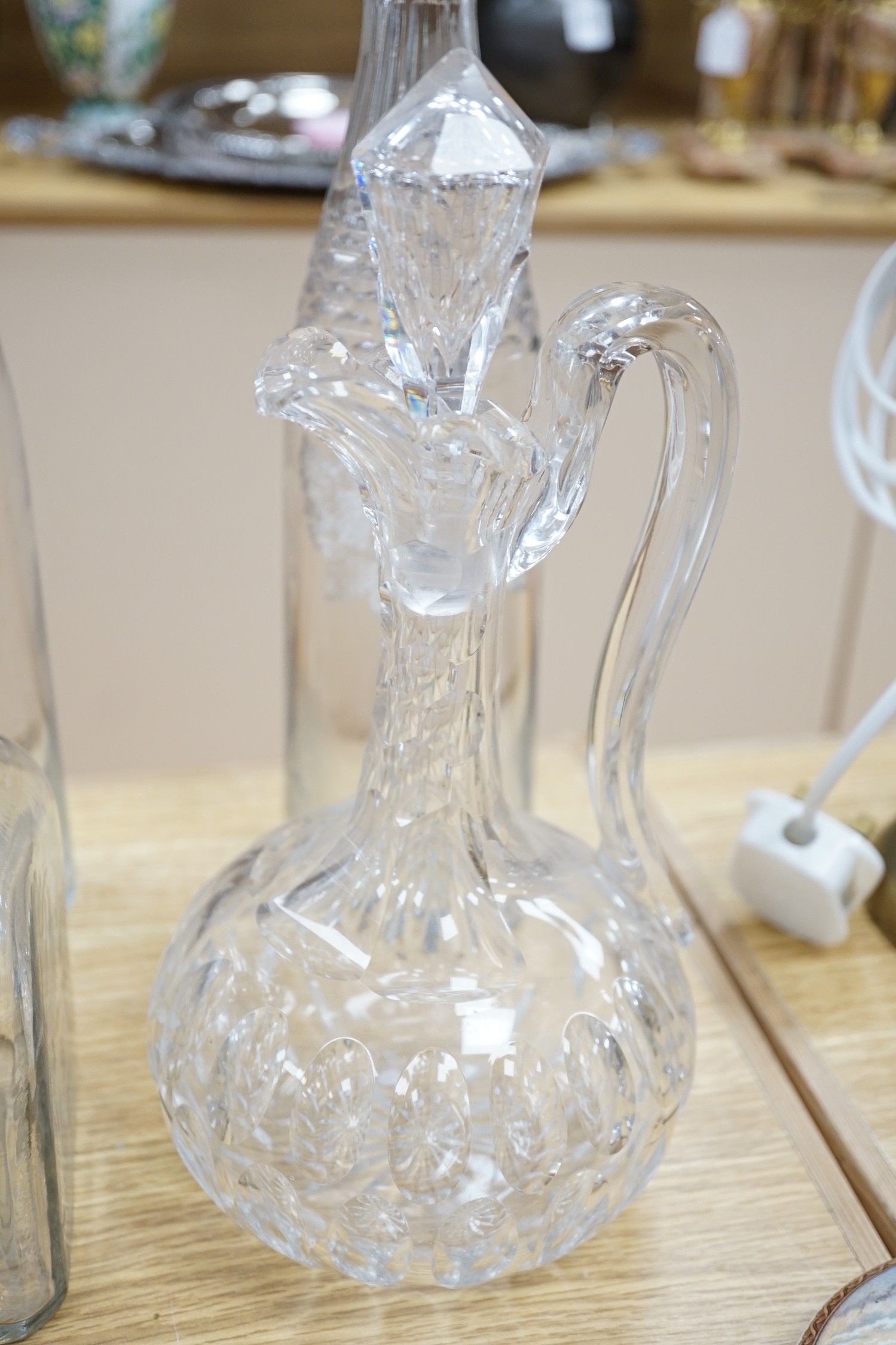 A Victorian cut glass Claret jug and stopper, a step cut pedestal jug, a pair of Dutch decanters, a large Dutch decanter and a set of three etched glass decanters named Kirsch, Cognac & Rhum